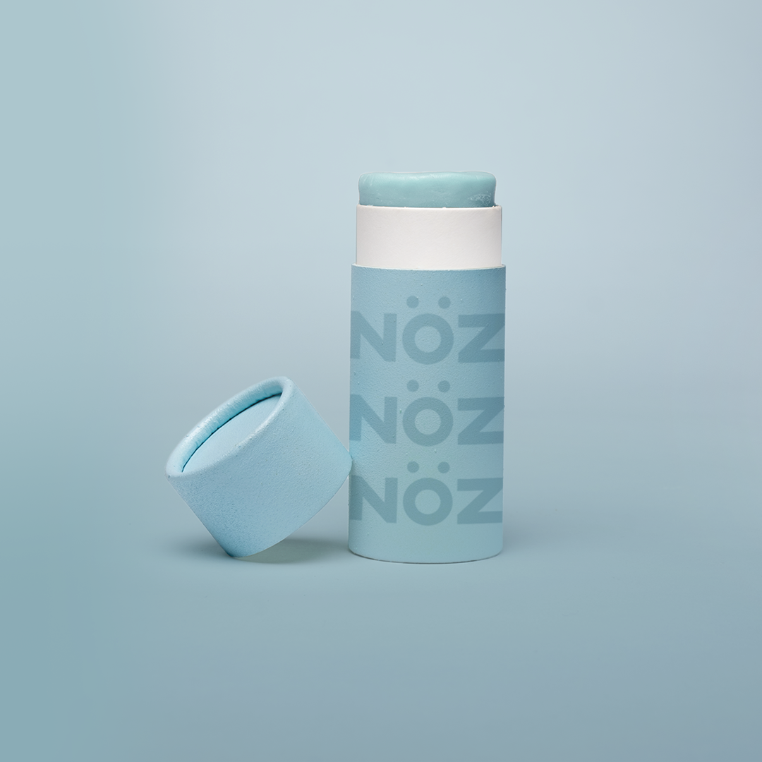 A stick of Noz’s reef-safe sunscreen in teal with the cap off