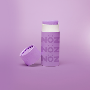 A stick of Noz’s reef-safe sunscreen in purple with the cap off