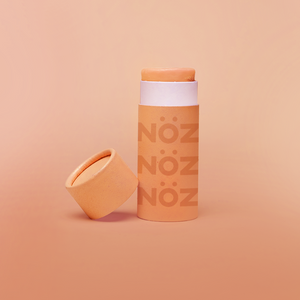 A stick of Noz’s reef-safe sunscreen in orange with the cap off